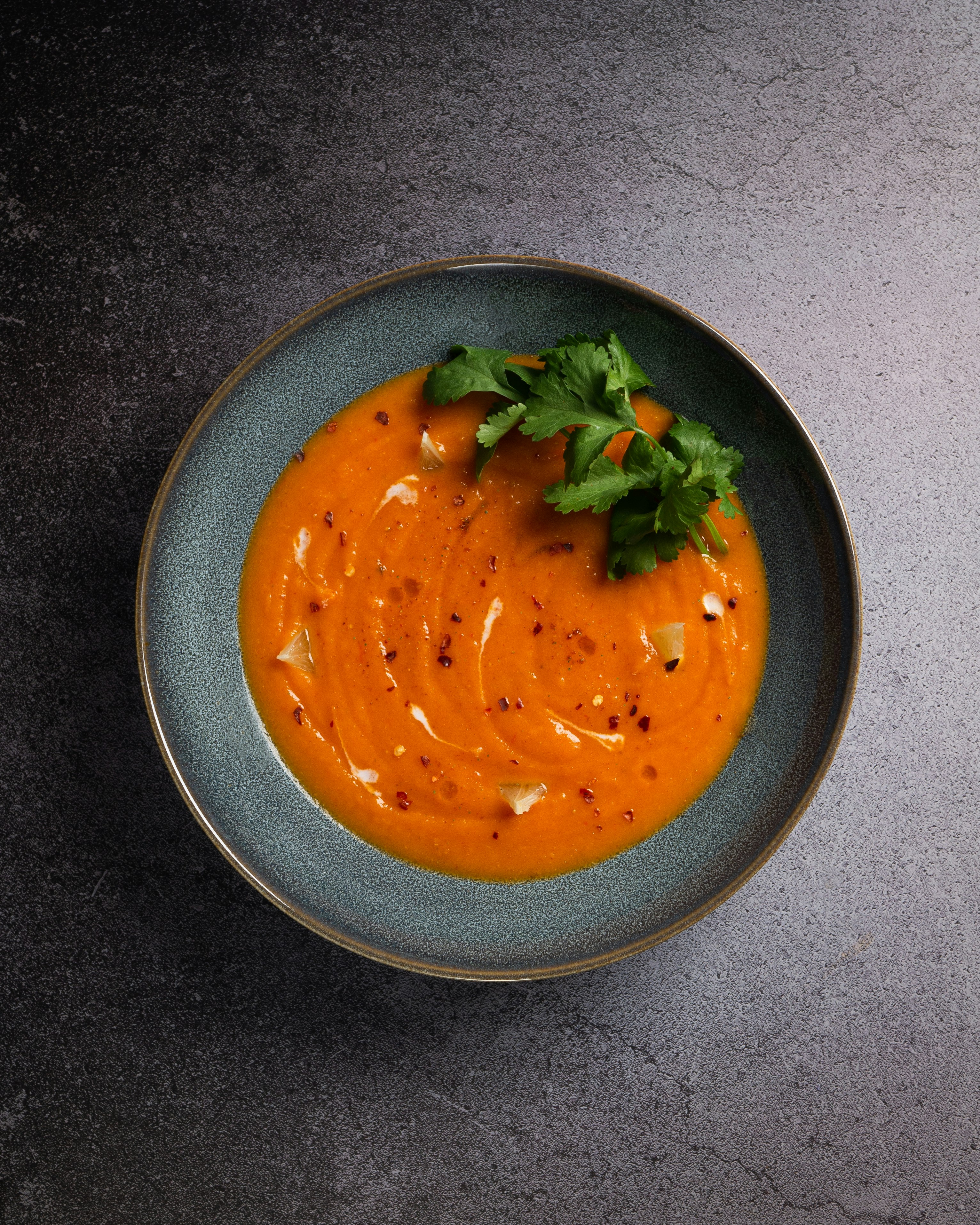 orange soup in black ceramic bowl